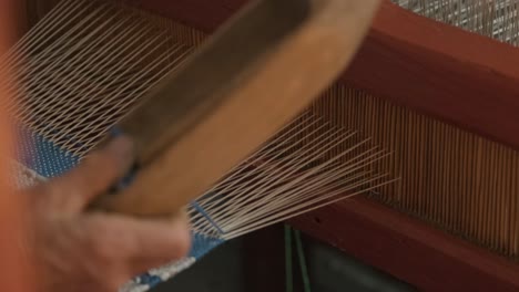 el tejedor hace tela en el telar étnico