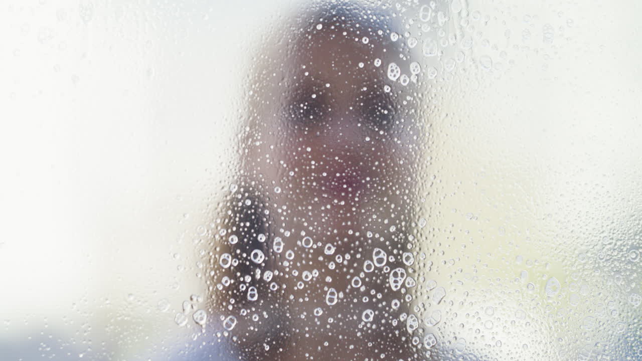 뒤에 사람이 있는 물 반점이 있는 창문