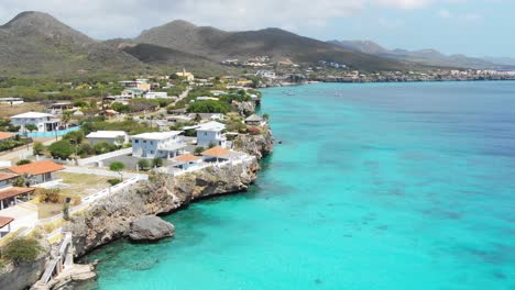 coastal town on playa kalki, curaçao with turquoise waters and clear skies, aerial view