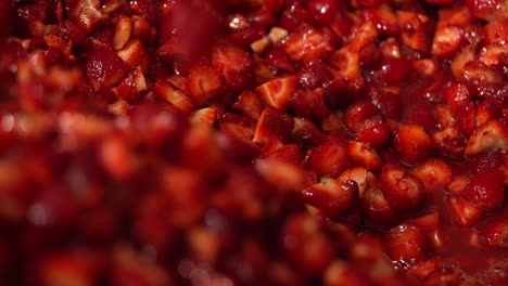 juicy strawberries in production being scooped and stirred