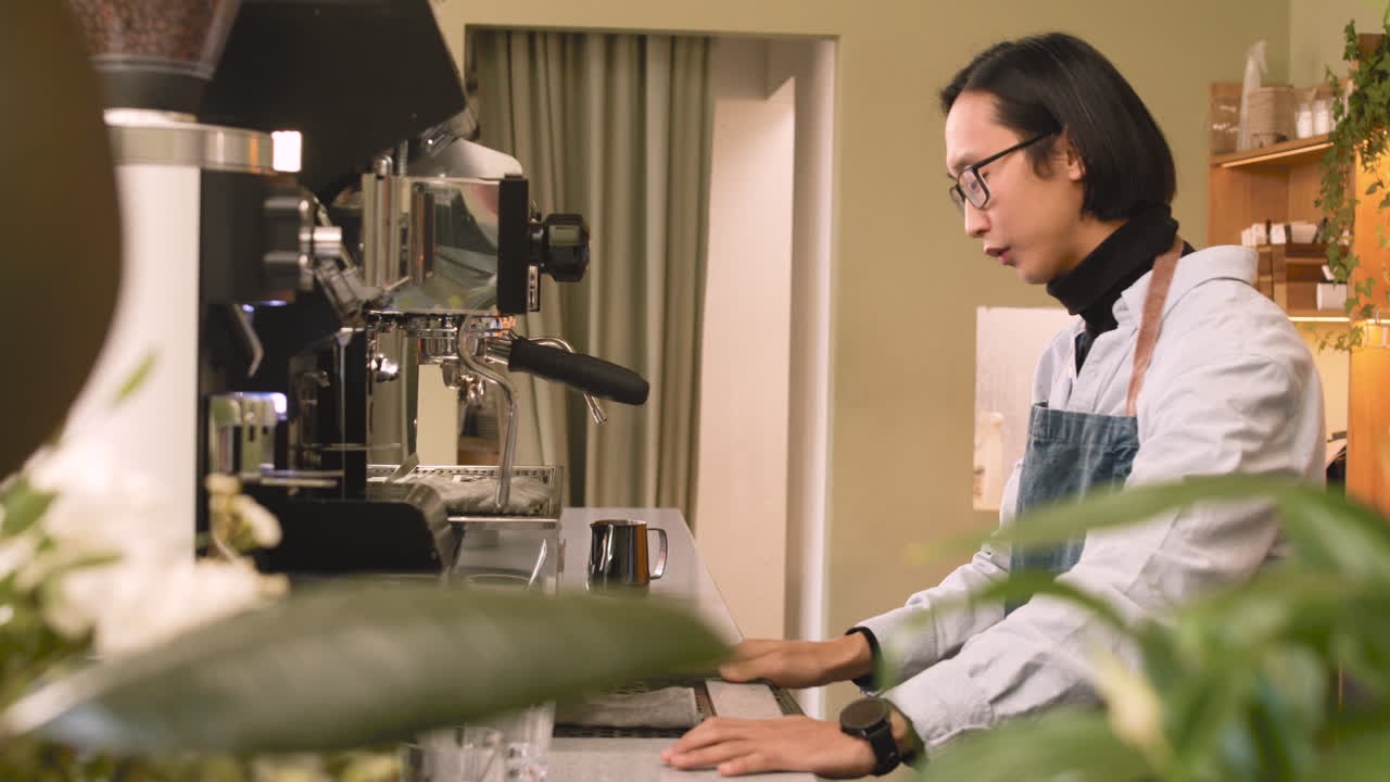 커피숍 카운터 뒤에서 동료에게 인사하는 웨이터