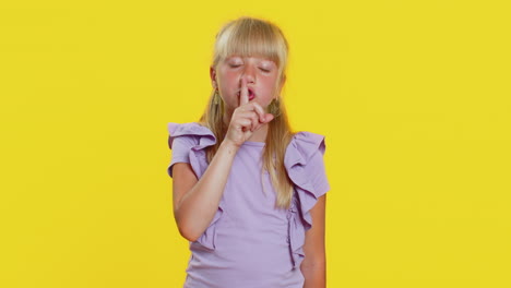 preteen child girl presses finger to lips makes silence hush sign do not tells gossip secret quiet