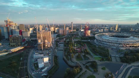 West-Ham-United-football-stadium-with-London-city-landmark-venue-aerial-view-dolly-right-across-cityscape