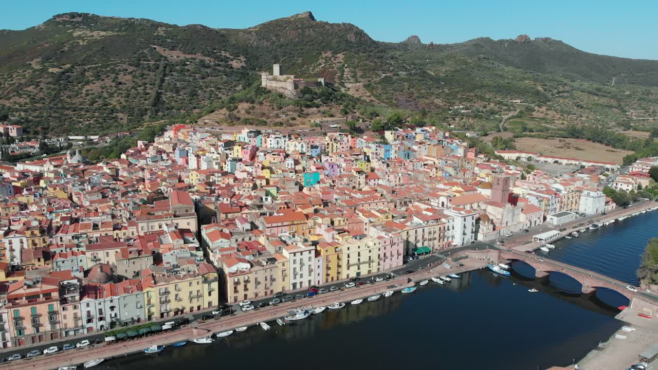 Ripresa aerea: Drone che si allontana dal Castello di Serravalle e dalla colorata Bosa, Sardegna, Italia