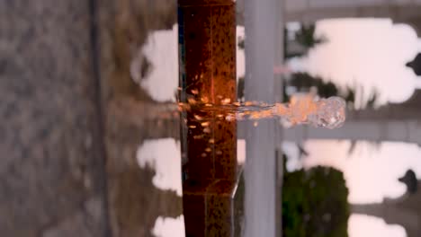 simple stream of water in a garden fountain at sunset at a palace, courtyard, mosque, or garden - vertical