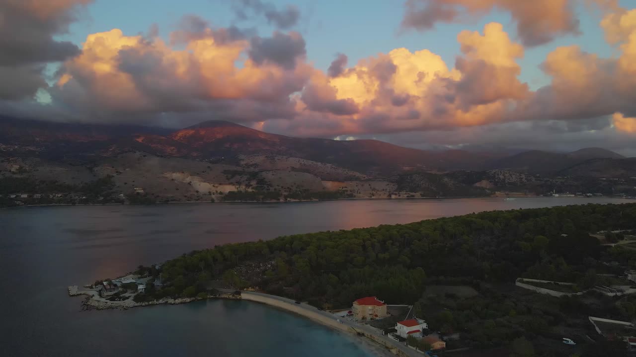Doline di Argostoli al tramonto durante l'ora d'oro con paesaggio montano e nuvole rosa