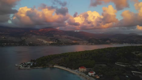 Sinkholes-of-Argostoli-by-sunset-during-golden-hour-with-mountain-landscape-and-pink-clouds