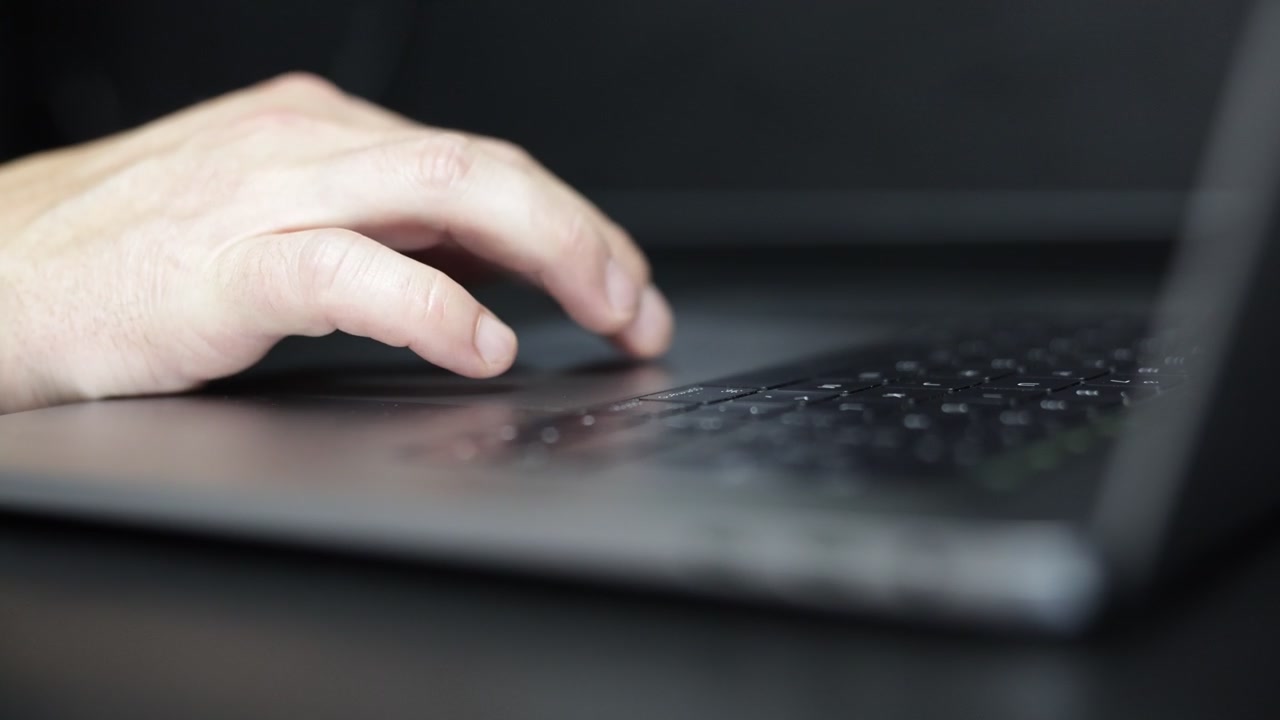 Close-up footage of a hand scrolling and clicking a computer mouse in a professional workspace, ideal for technology, office work, online browsing, and productivity concepts.