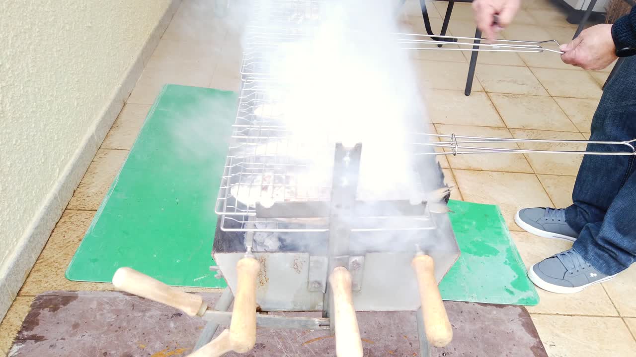 Fresh fish cooking on a barbecue grill over open heat. Close-up of whole fish grilling on a BBQ with natural fire and smoke. Outdoor seafood cooking with simple preparation and authentic atmosphere