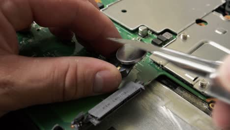 Repair of an old laptop, the technician is removing the battery