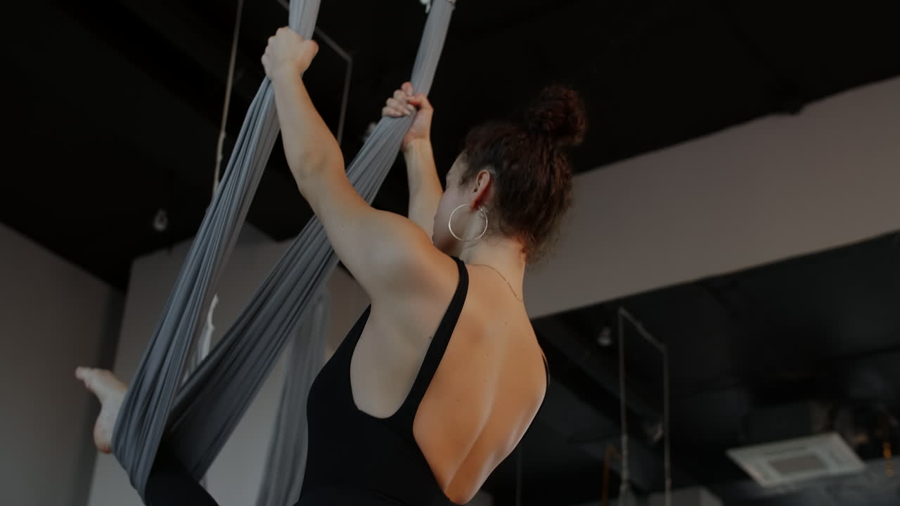 mujer practicando yoga aéreo