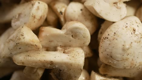 close up of sliced white mushrooms with black pepper