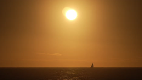 yacht sailing on the oceans horizon during a golden sunset