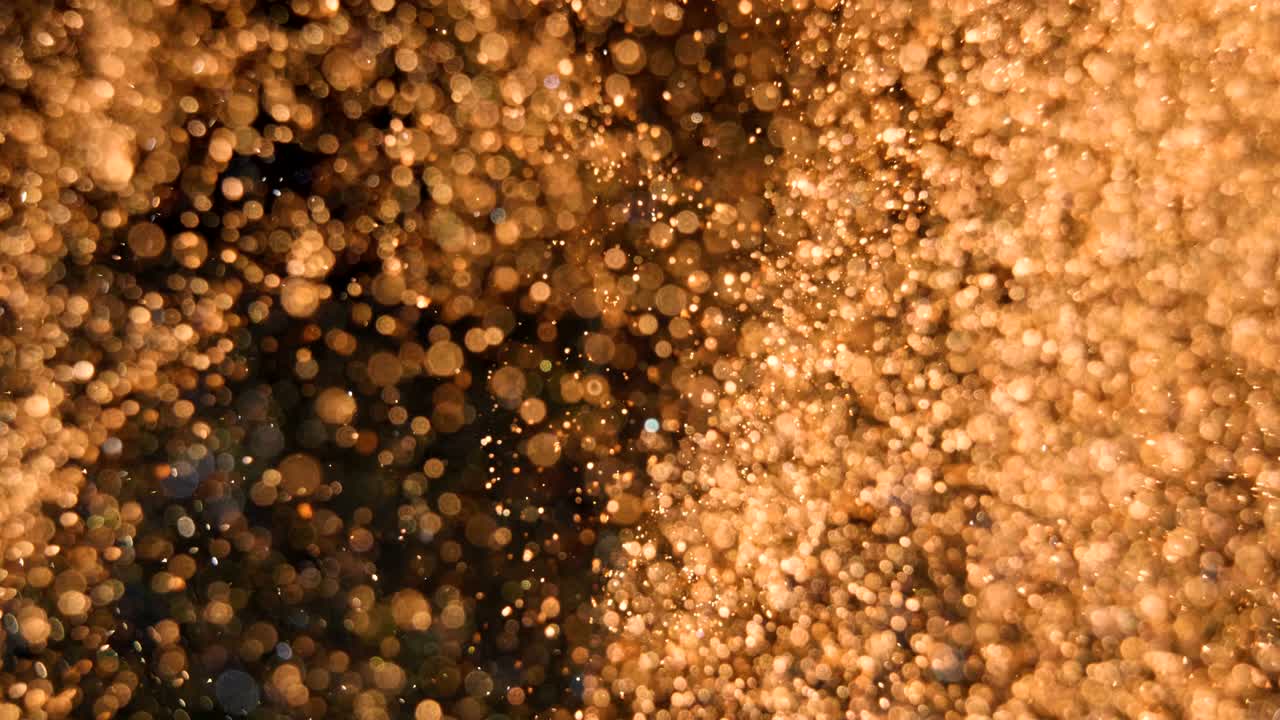 Elegant, detailed, and golden particles flow with shallow depth of field underwater
