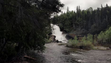 Enthüllen-Schuss-Von-Rutsche-Neigette-Wasserfall-Hinter-Den-Grünen-Bäumen-In-Rimouski,-Quebec,-Kanada