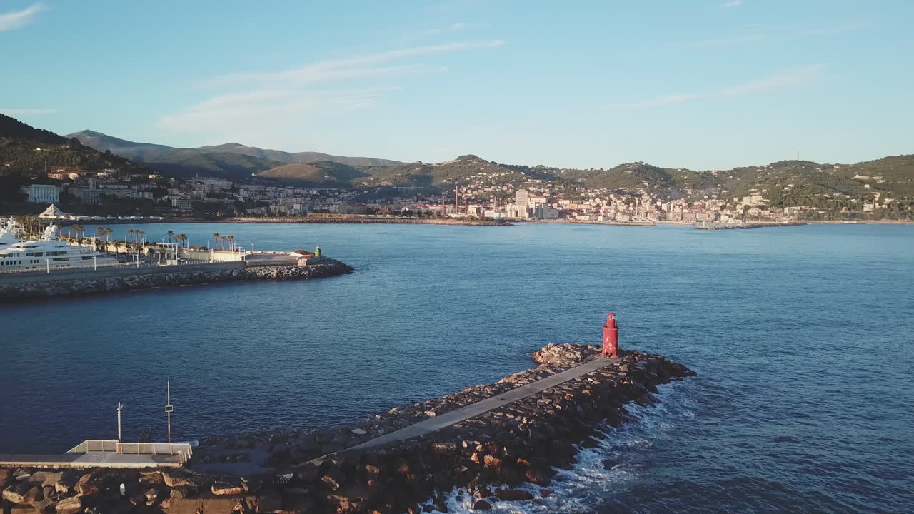 Vista aerea di un faro su un molo e di un porto.