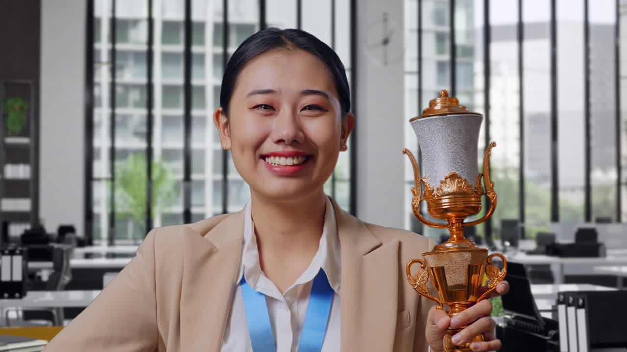 Woman Holding Trophy in Office