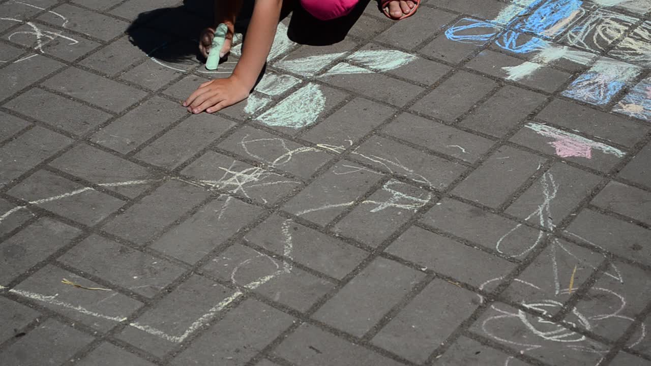 Children draws chalk. Shooting in the summer