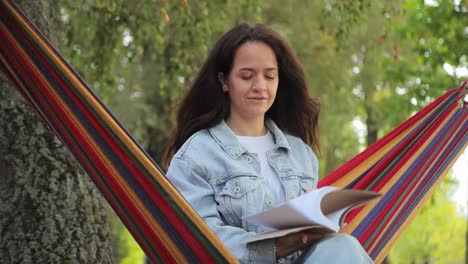 woman relaxing in hammock reading a book