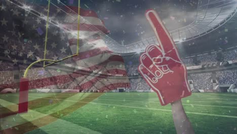Animation-of-american-flag-and-giant-pointing-hand,-over-pitch-and-crowd-at-sports-stadium