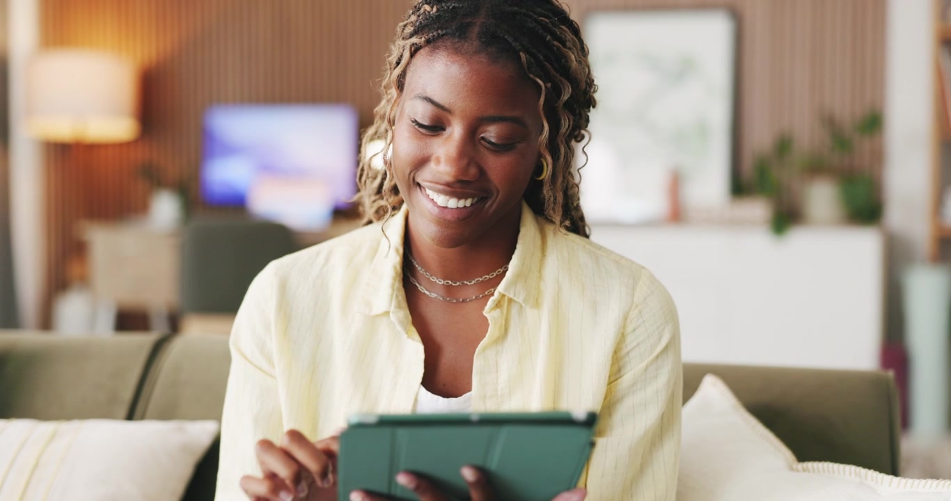 Young Woman Using Tablet on Sofa in Living Room