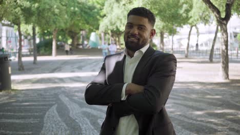 Confident-bearded-businessman-standing-with-crossed-arms.