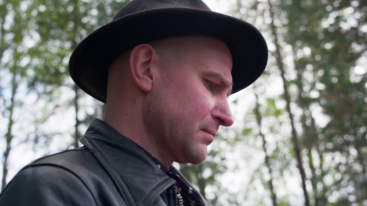 hombre caucásico con sombrero oscuro mira seriamente a su controlador de su avión no tripulado