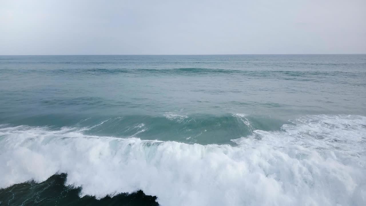 공중에서 드론으로 보는 큰 바다의 물결, 물결이 부히고 숨을  수 있는 푸른 바다, 바다 풍경과 스카이 라인에서 거품이 아집니다.