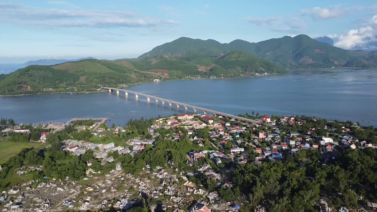 Góc nhìn từ drone trên không của thành phố biển Đà Nẵng với cây cầu dài bắc qua vịnh rộng được bao quanh bởi núi và các tòa nhà đô thị dọc bờ biển miền Trung Việt Nam