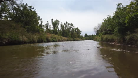 toma aérea volando más allá de una familia navegando en kayak por un río marrón