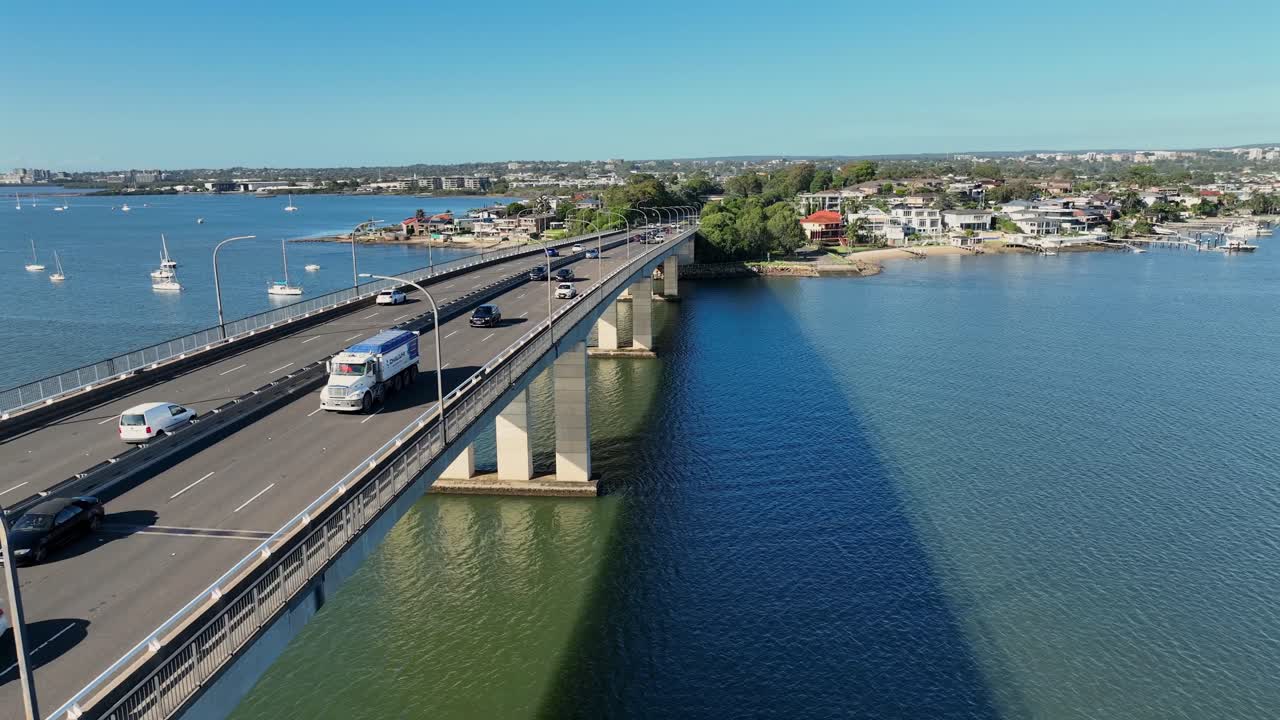 Ripresa con drone che vola basso contro il flusso del traffico sul ponte Captain Cook a Sydney, Australia