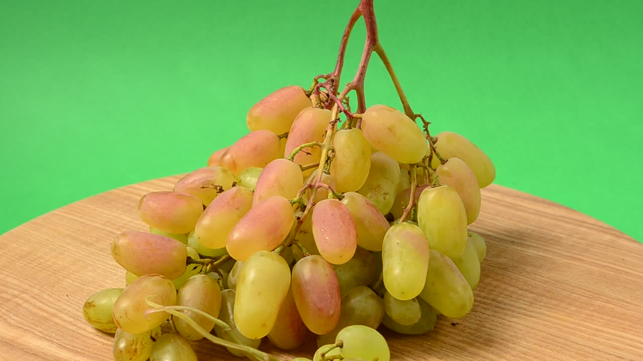 Uva su un tagliere da cucina. Ripresa in movimento