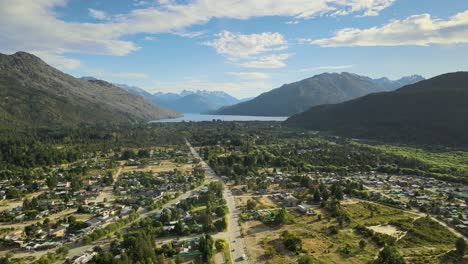 dolly in flying over lago puelo valley surrounded by pine tree woods and andean mountains with lake in background at sunset, chubut, patagonia argentina