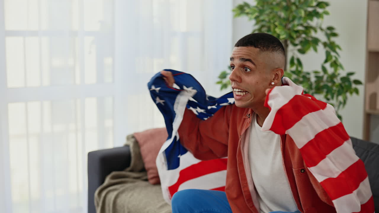 Man watching a sporting event while holding the American flag