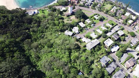 drone-footage-on-the-North-Shore-of-Oahu-Hawaii-tilting-up-from-the-coastal-residential-area-to-the-blue-water-and-white-sand-beaches-backed-by-the-lush-green-mountains-of-the-island