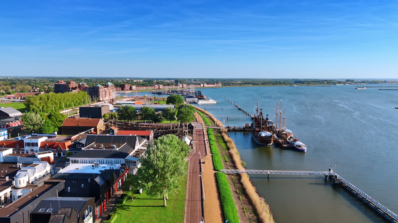 Approaching wharf and museum Batavia Land in Lelystad, Netherlands. Boats and reconstruction of a ship are at the berth.
