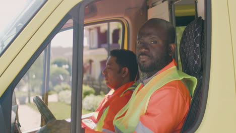 american ambulance driver talking by radio and receiving information from the hospital and then he looks at the camera