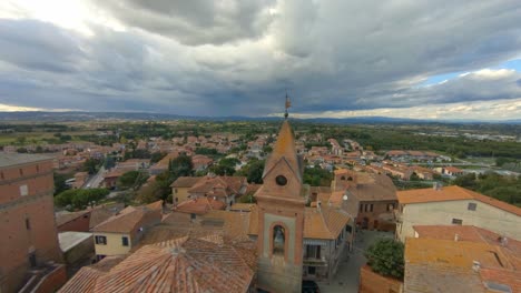 drone flying above roofs towards the church of san cristoforo in sinalunga, italy - aerial, fpv