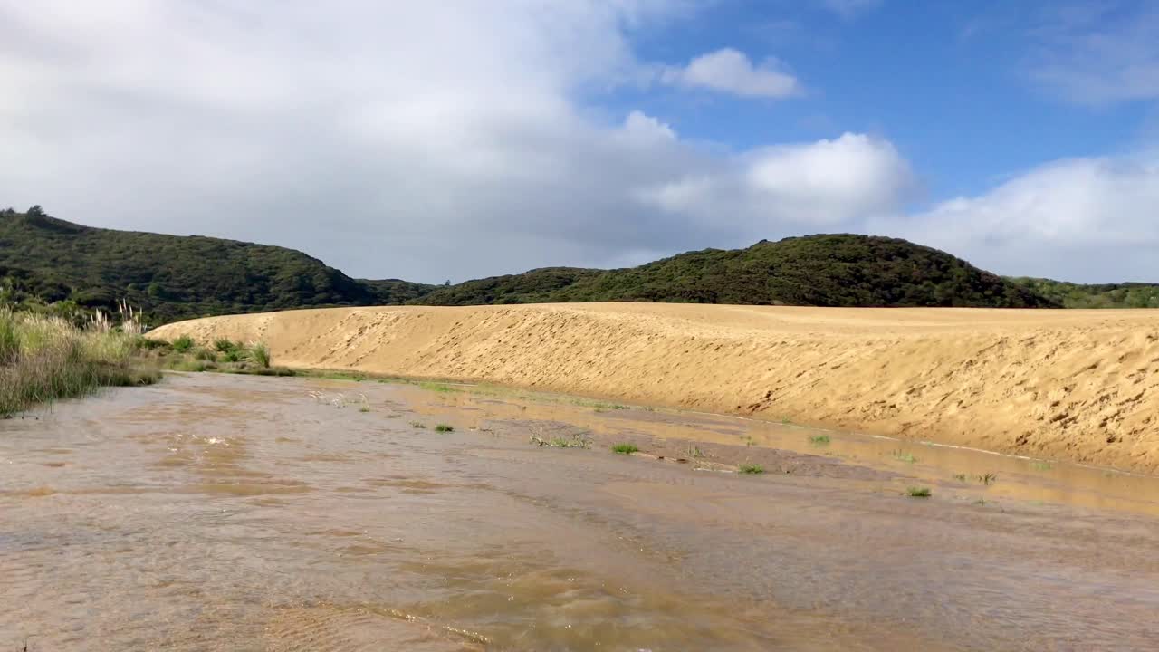 Il Torrente Te Paki scorre dolcemente durante il giorno a Ninety Mile Beach, Northland, Nuova Zelanda.