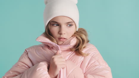 teenage caucasian girl with winter clothes feeling cold in front of the camera.