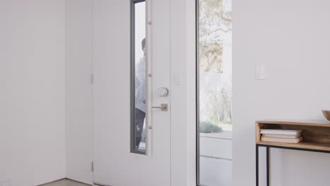 father bringing excited children back home from school opens front door of house