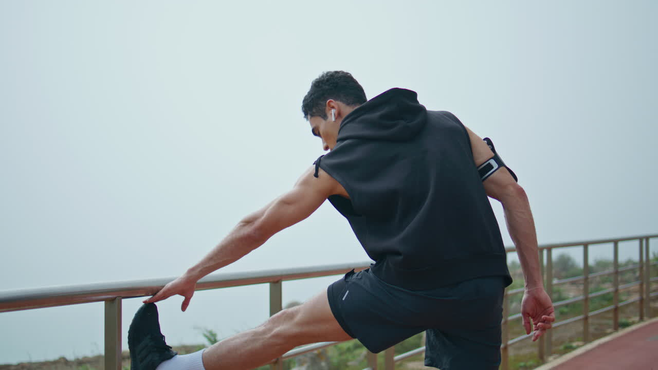 달리기 트랙에서 운동을 하는 운동선수. 근육이 적합한 사람이 몸을 따뜻하게 합니다.