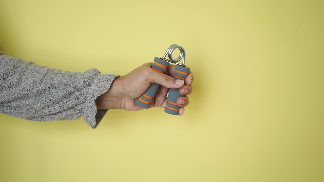Primo piano di una mano che stringe un attrezzo per rafforzare la presa.