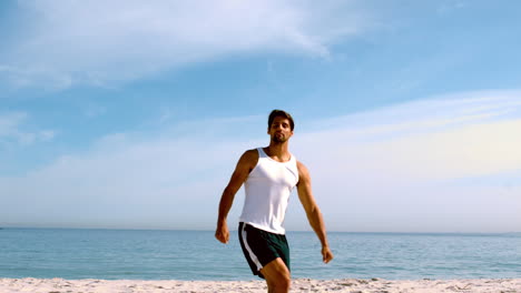 Mann-Springt-Mit-Erhobenen-Armen-Am-Strand