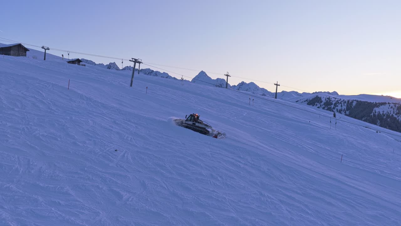 Il drone riprende battipista che mantengono le piste da sci nella Zillertal Arena con un'enorme copertura nevosa a Krimml e Königsleiten, Austria, e montagne alpine panoramiche.