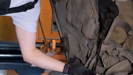 mechanic working on car undercarriage in workshop