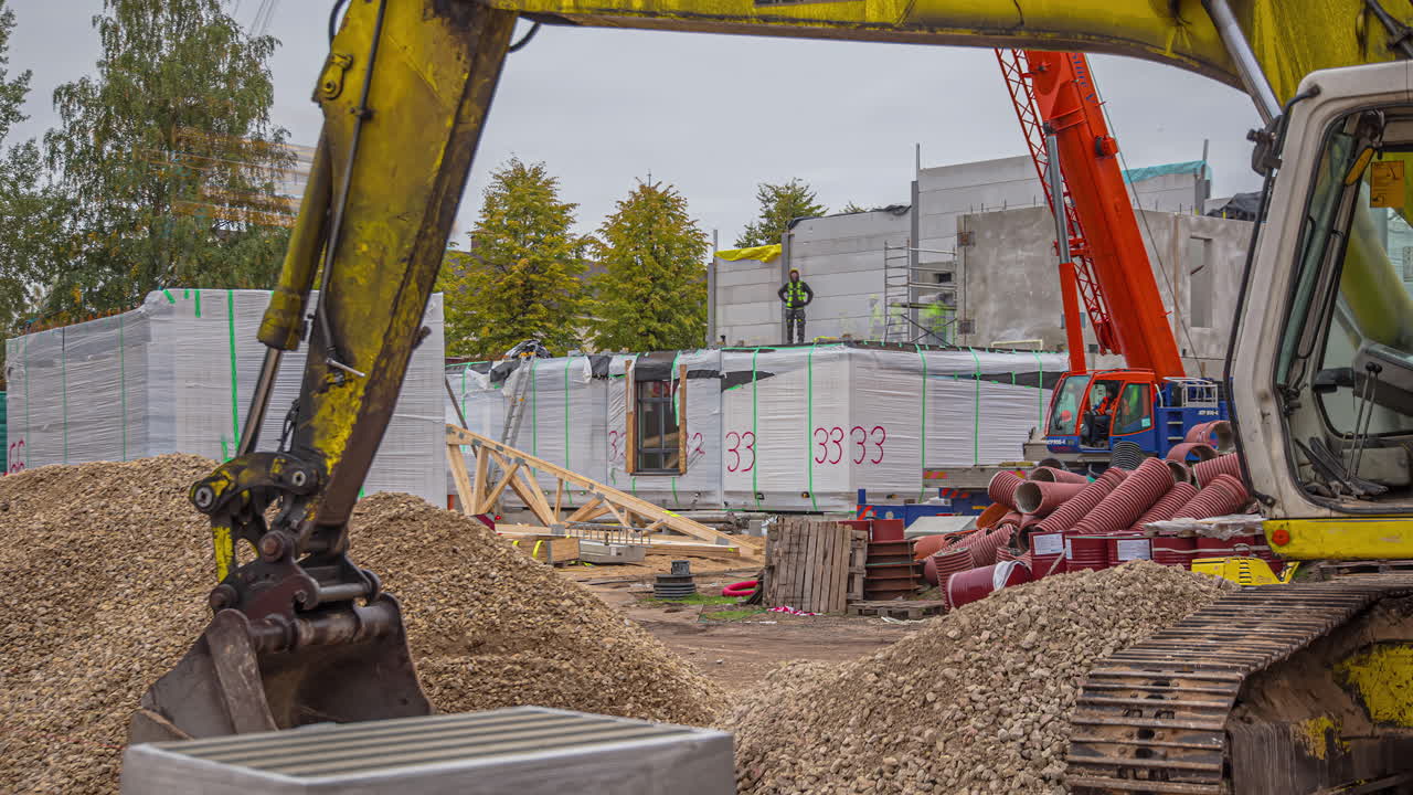 mirando bajo el brazo o el brazo de una excavadora a las personas que trabajan en un sitio de construcción - lapso de tiempo