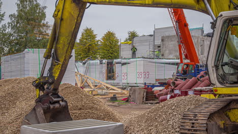 Blick-Unter-Den-Arm-Oder-Ausleger-Eines-Baggers-Auf-Menschen,-Die-Auf-Einer-Baustelle-Arbeiten---Zeitraffer