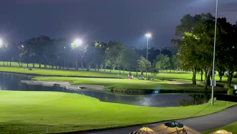 golfers playing under bright lights at night