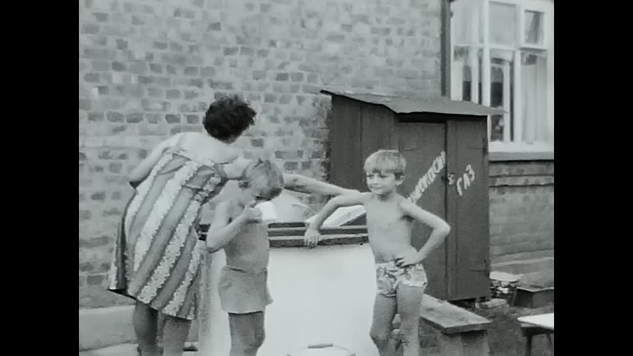 Group of Children Gathered Around draw-well in Soviet Union Archive. CIRCA USSR 1970: A group of children in the Soviet Union standing around a draw-well in an archive.